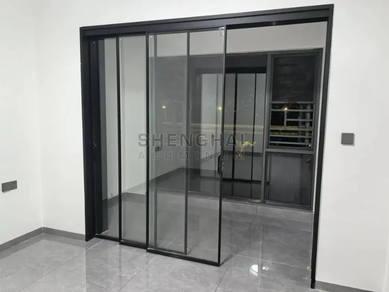 Modern ultra-slim black aluminum sliding glass doors installed in a minimalist interior, maximizing natural light and space.