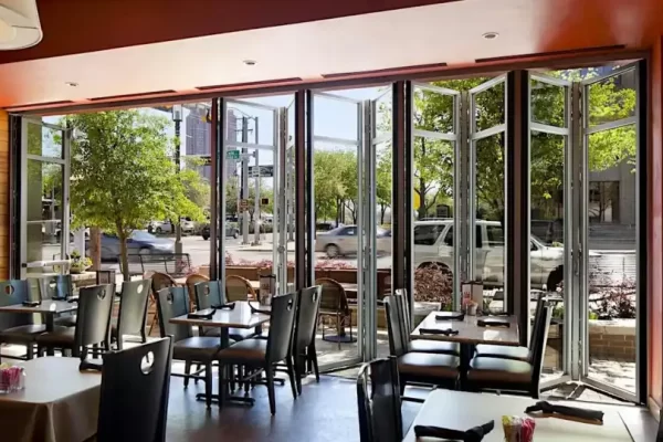 Heavy-duty commercial folding door systems providing a wide opening for a high-traffic street-facing restaurant.